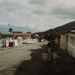 Quiet suburban street in Mérida, Venezuela, featuring tile-roofed houses and mountain views.