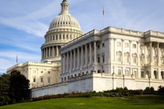 A picturesque view of the US Capitol Building in Washington, DC, under a clear sky.
